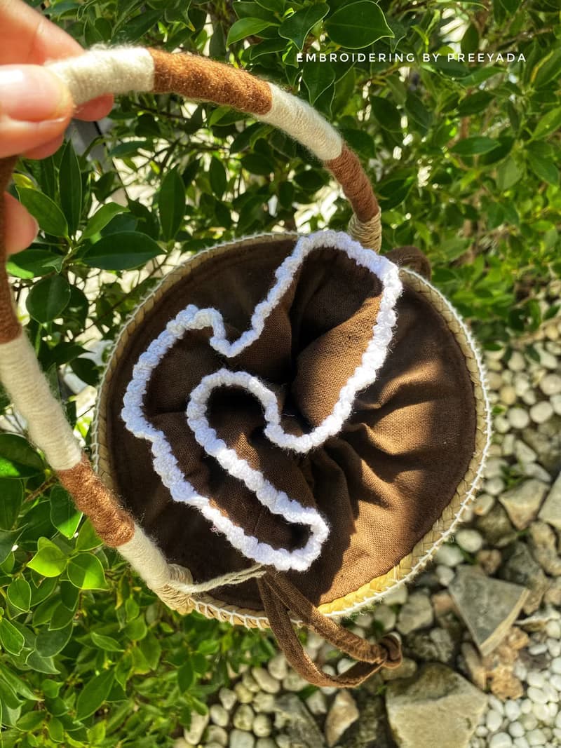 Thai woven rattan bag with hand-embroidered daisy and rabbit pattern