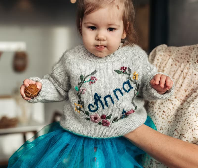 Handmade alpaca sweater with baby's name and embroidered flowers. First gift.