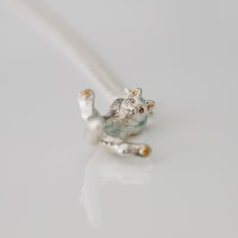 両手で星をつかんだ白猫ペンダント