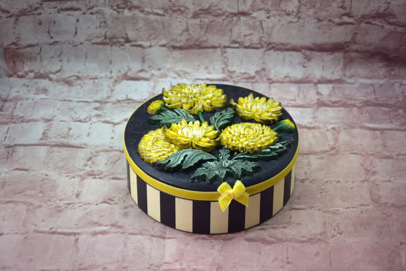 Round jewelry storage box with voluminous yellow chrysanthemum flowers