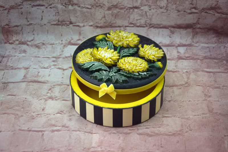 Round jewelry storage box with voluminous yellow chrysanthemum flowers
