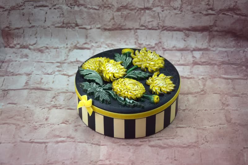 Round jewelry storage box with voluminous yellow chrysanthemum flowers