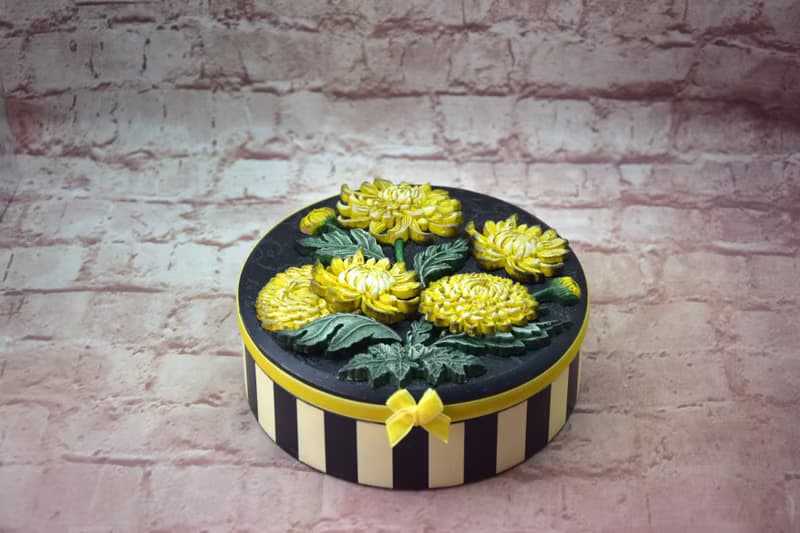 Round jewelry storage box with voluminous yellow chrysanthemum flowers