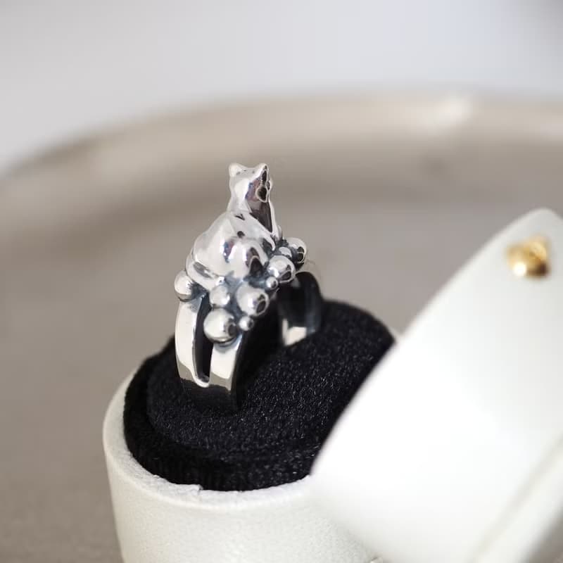 何かの上に香箱座り猫リング