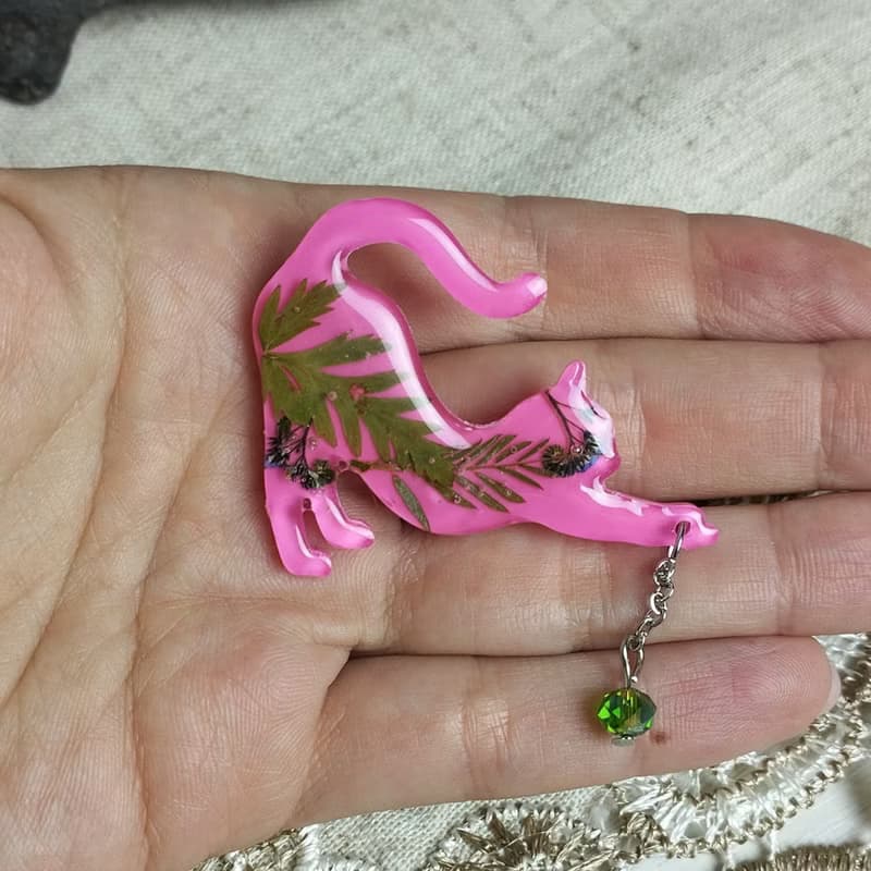 粉紅貓別針。帶有綠葉的粉紅色貓胸針。手工製作的樹脂胸針。