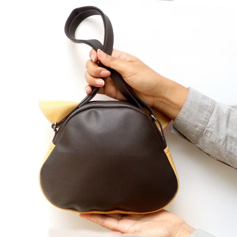 Orange cat crossbody bag is compact fro carrying mobile phones.