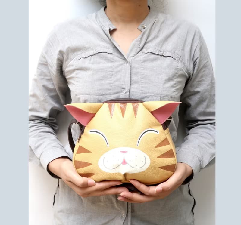 Orange cat crossbody bag is compact fro carrying mobile phones.