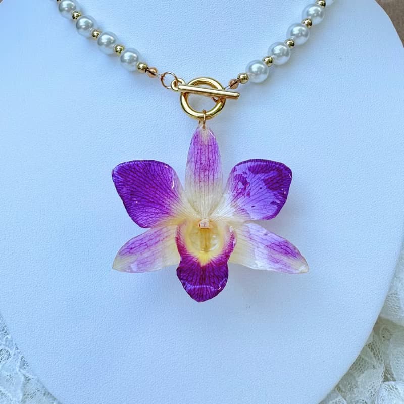 Purple Dendrobium with pearl and gold bead necklace