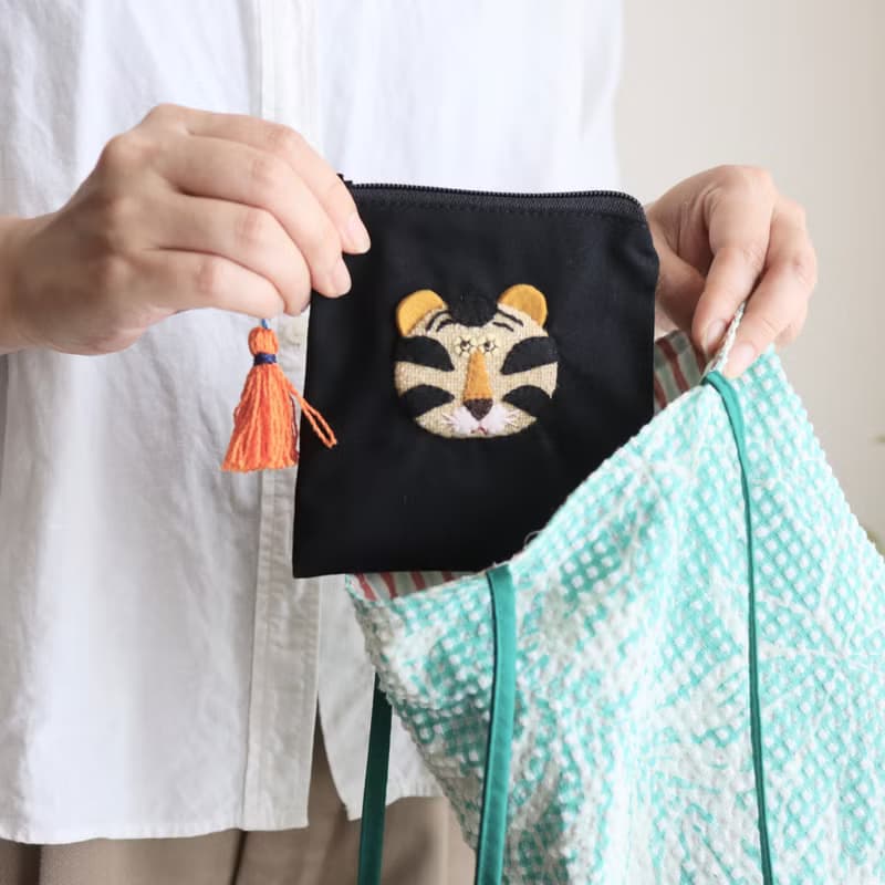 刺しゅう風アップリケ ほっこりトラの黒ポーチ カラフルタッセルつき