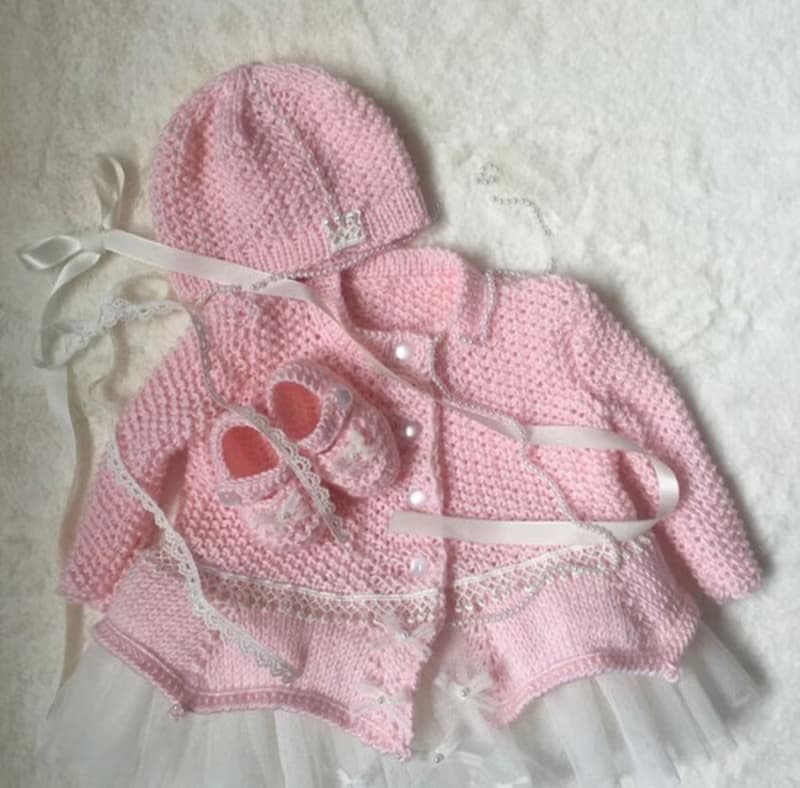 Hand knit pink outfit for baby girl. Dress with pearls and lace, hat, booties.
