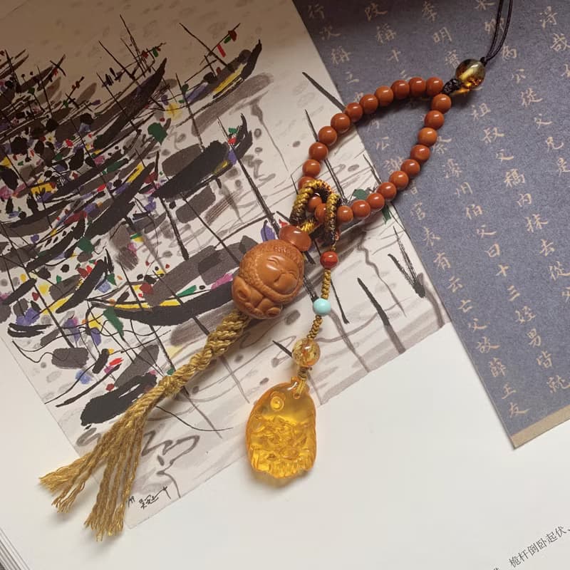手作 遙遙。天然橄欖核獅子編織背包鏈 金珀南紅跑圈核尖珠手機繩