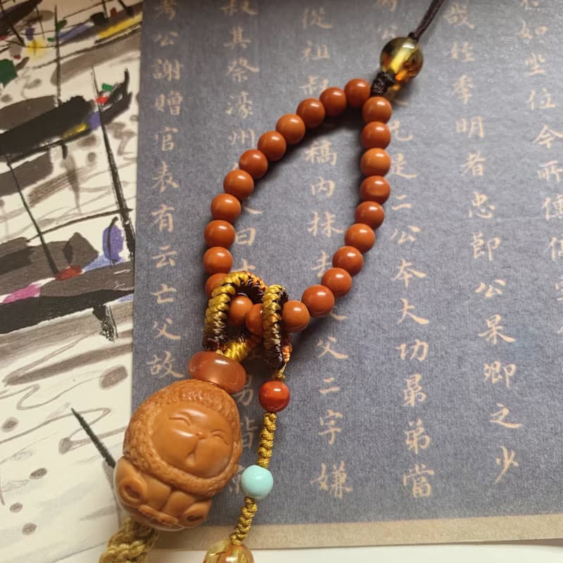 手作 遙遙。天然橄欖核獅子編織背包鏈 金珀南紅跑圈核尖珠手機繩