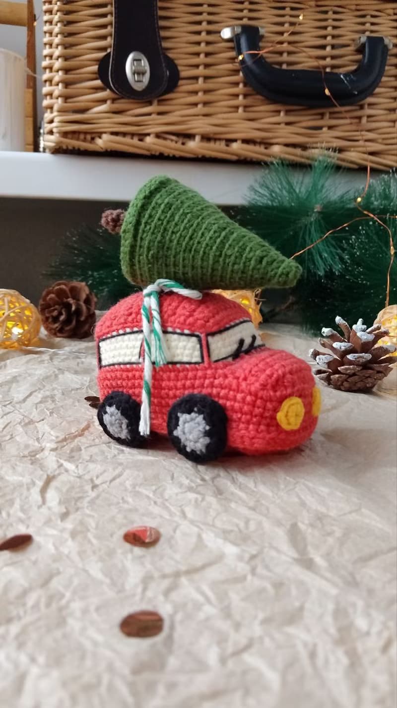 Red car with Christmas tree for gift. Holiday toy home decor. New year red car