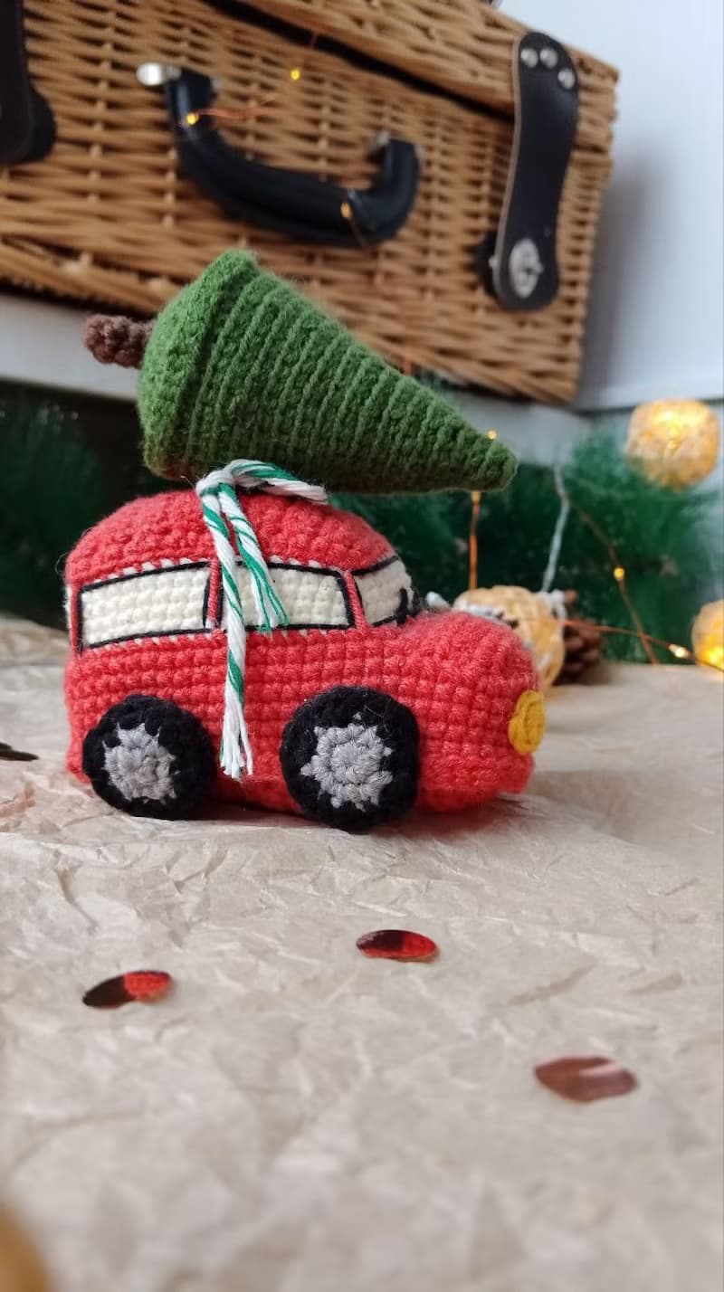Red car with Christmas tree for gift. Holiday toy home decor. New year red car