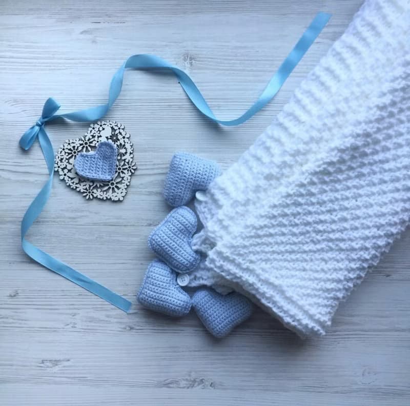 Hand knit white blanket with blue, or pink hearts toys for baby. Baptism blanket