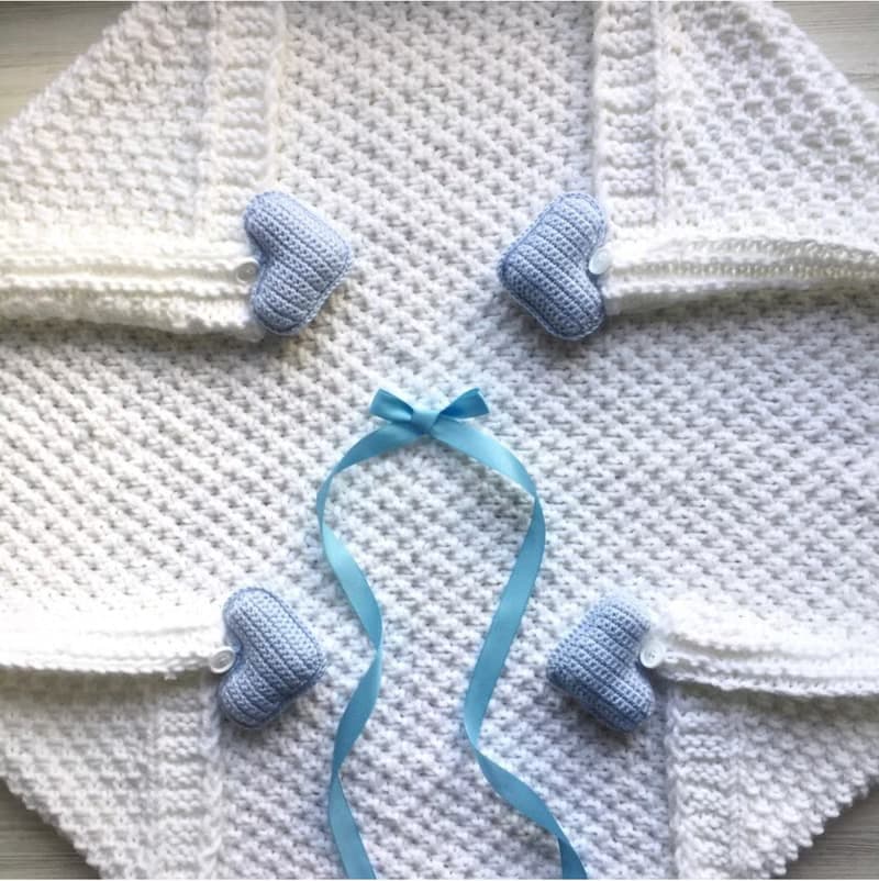 Hand knit white blanket with blue, or pink hearts toys for baby. Baptism blanket