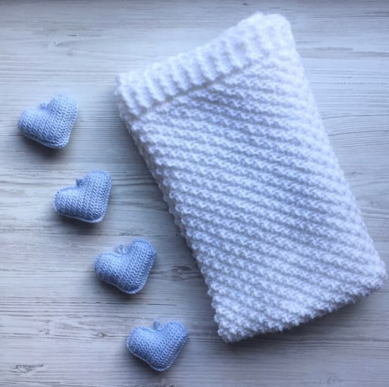 Hand knit white blanket with blue, or pink hearts toys for baby. Baptism blanket