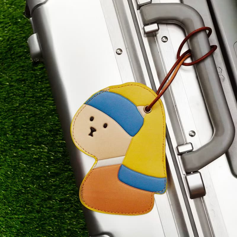 戴珍珠耳環的少女貓皮革行李牌