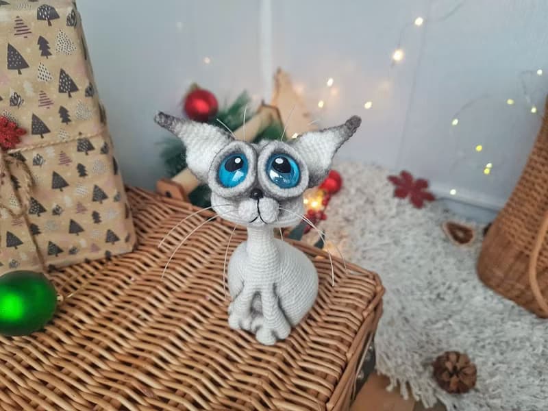 Siamese cat toy sculpture . Knitting sitting realistic pet replica. Cat toy