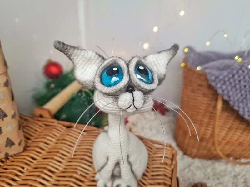 Siamese cat toy sculpture . Knitting sitting realistic pet replica. Cat toy