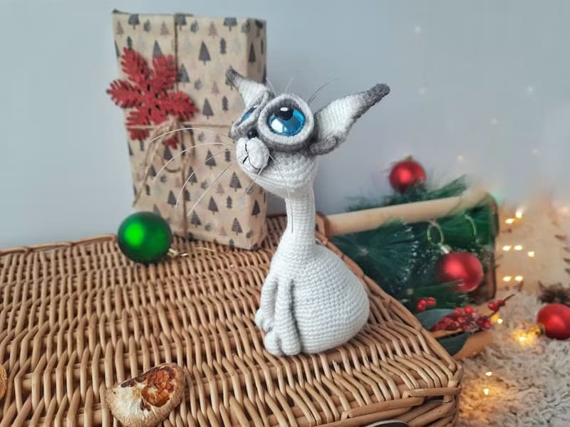Siamese cat toy sculpture . Knitting sitting realistic pet replica. Cat toy