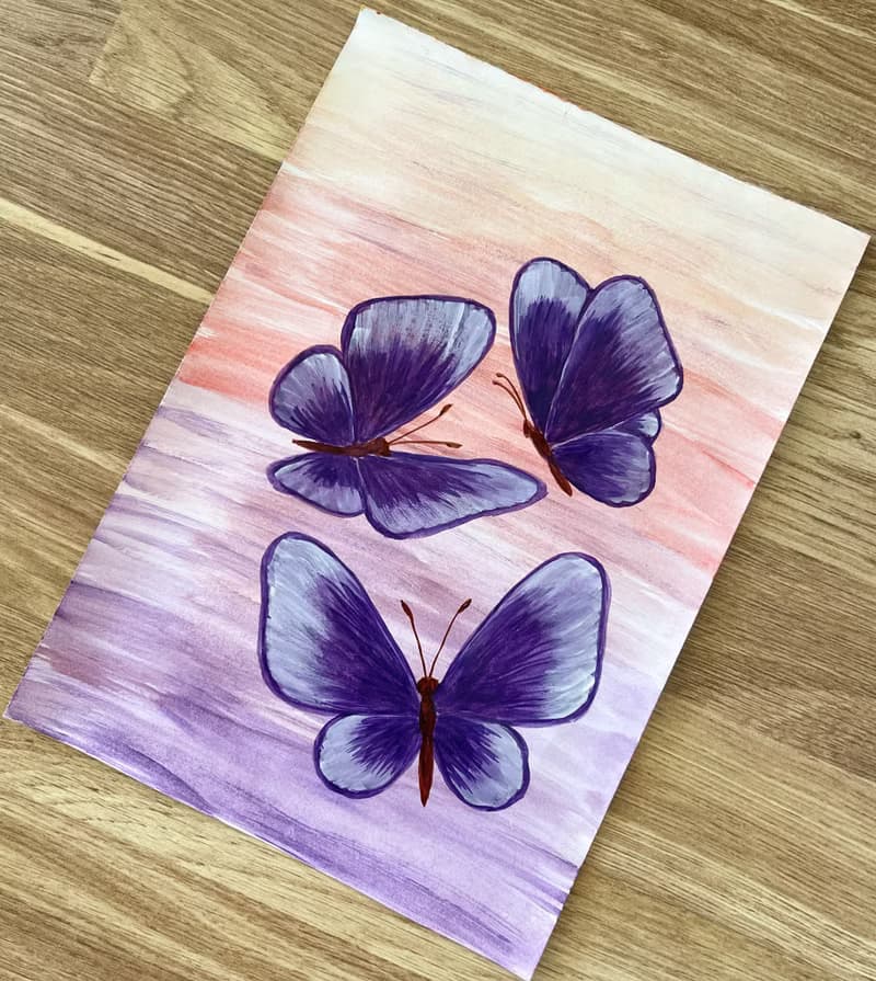 Purple butterflies on a lilac-peach background. Watercolor.