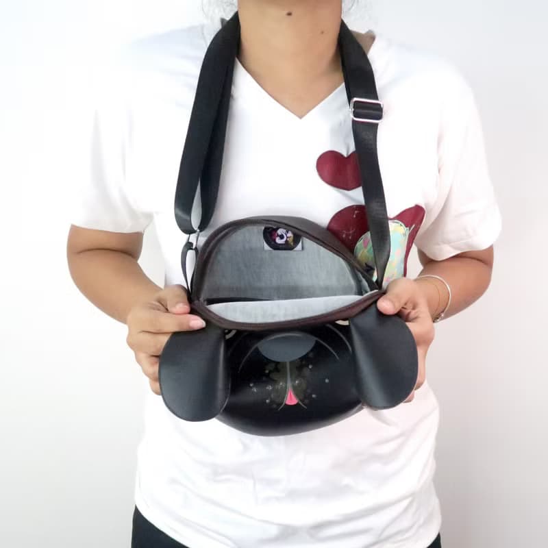 Black french bulldog crossbody bag is compact fro carrying mobile phones.