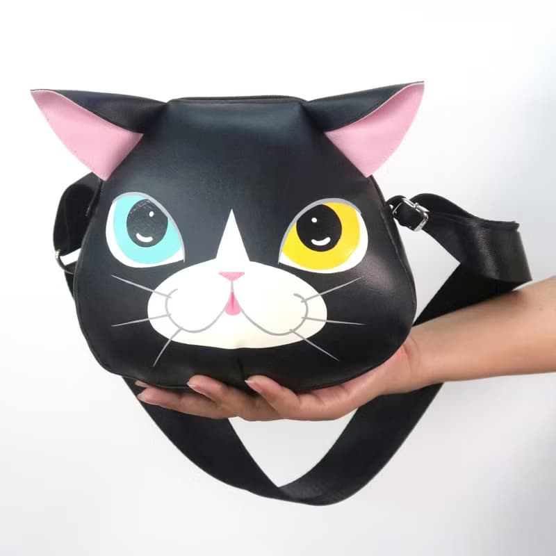 Black cat crossbody bag is compact fro carrying mobile phones.