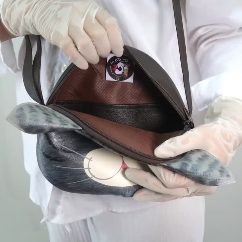 Black cat crossbody bag is compact fro carrying mobile phones.