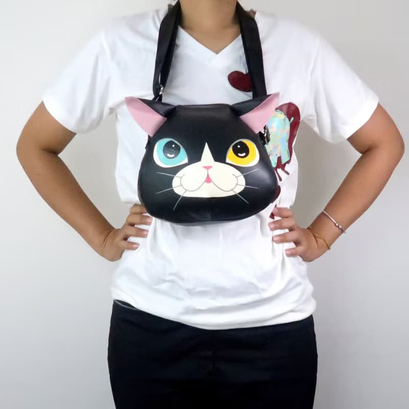 Black cat crossbody bag is compact fro carrying mobile phones.