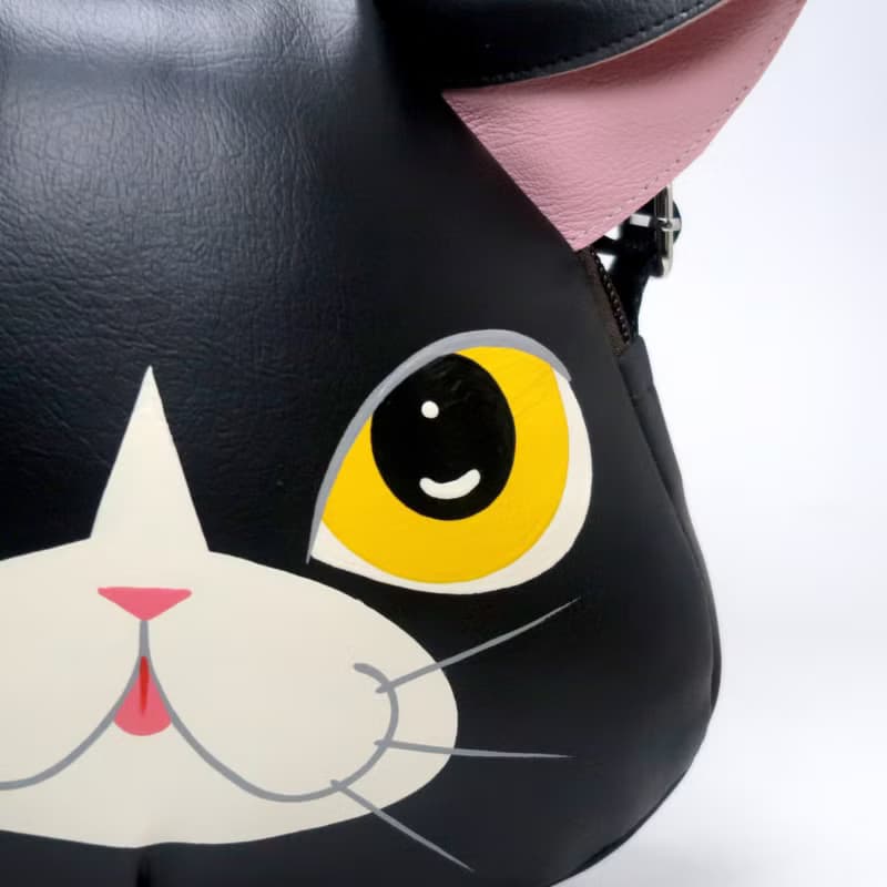 Black cat crossbody bag is compact fro carrying mobile phones.