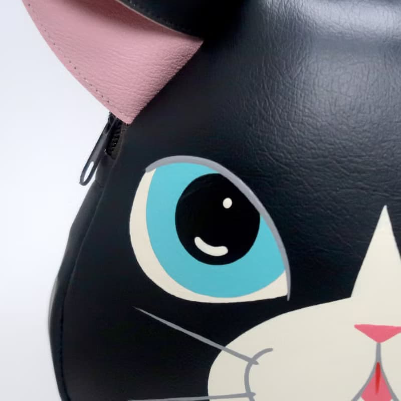 Black cat crossbody bag is compact fro carrying mobile phones.