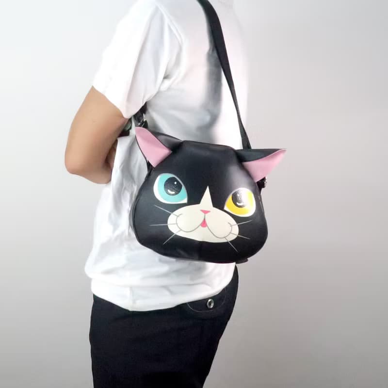Black cat crossbody bag is compact fro carrying mobile phones.