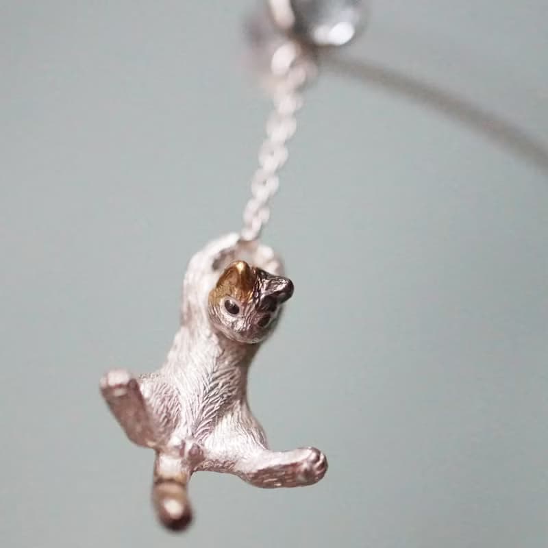 風船と飛んでいく三毛猫のピアス 片耳