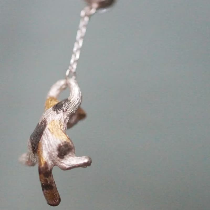 風船と飛んでいく三毛猫のピアス 片耳