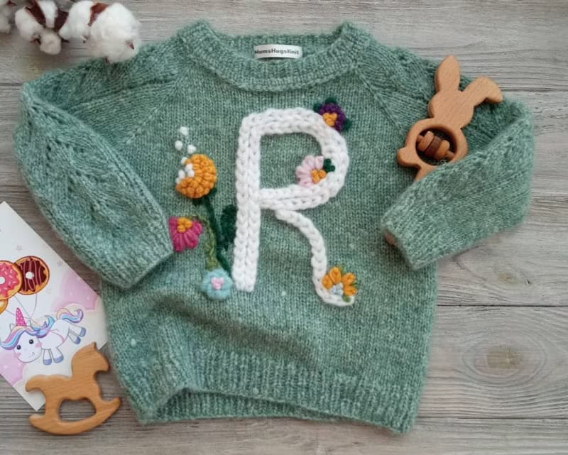 Handmade alpaca sweater with baby's name and embroidered flowers. Gift for girl.