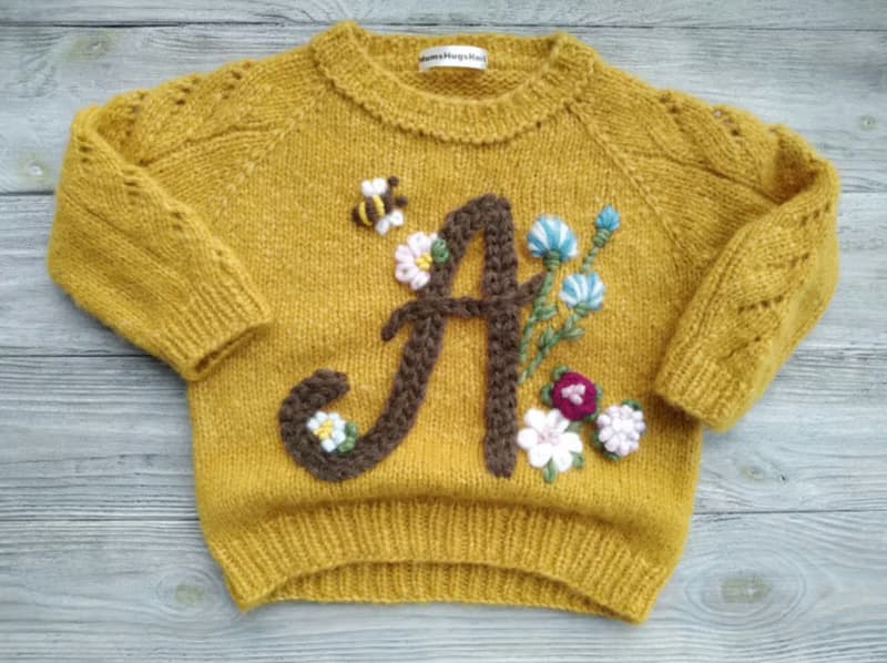 Handmade alpaca sweater with baby's name and embroidered flowers. Gift for girl.