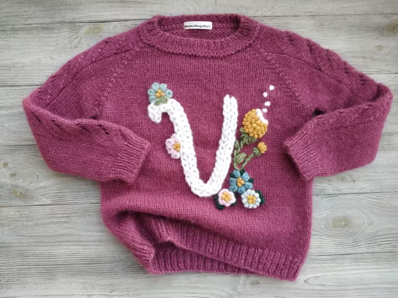 Handmade alpaca sweater with baby's name and embroidered flowers. Gift for girl.