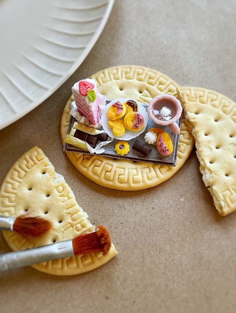 Miniature set of a piece of cake with strawberries, chocolate and a cup of tea