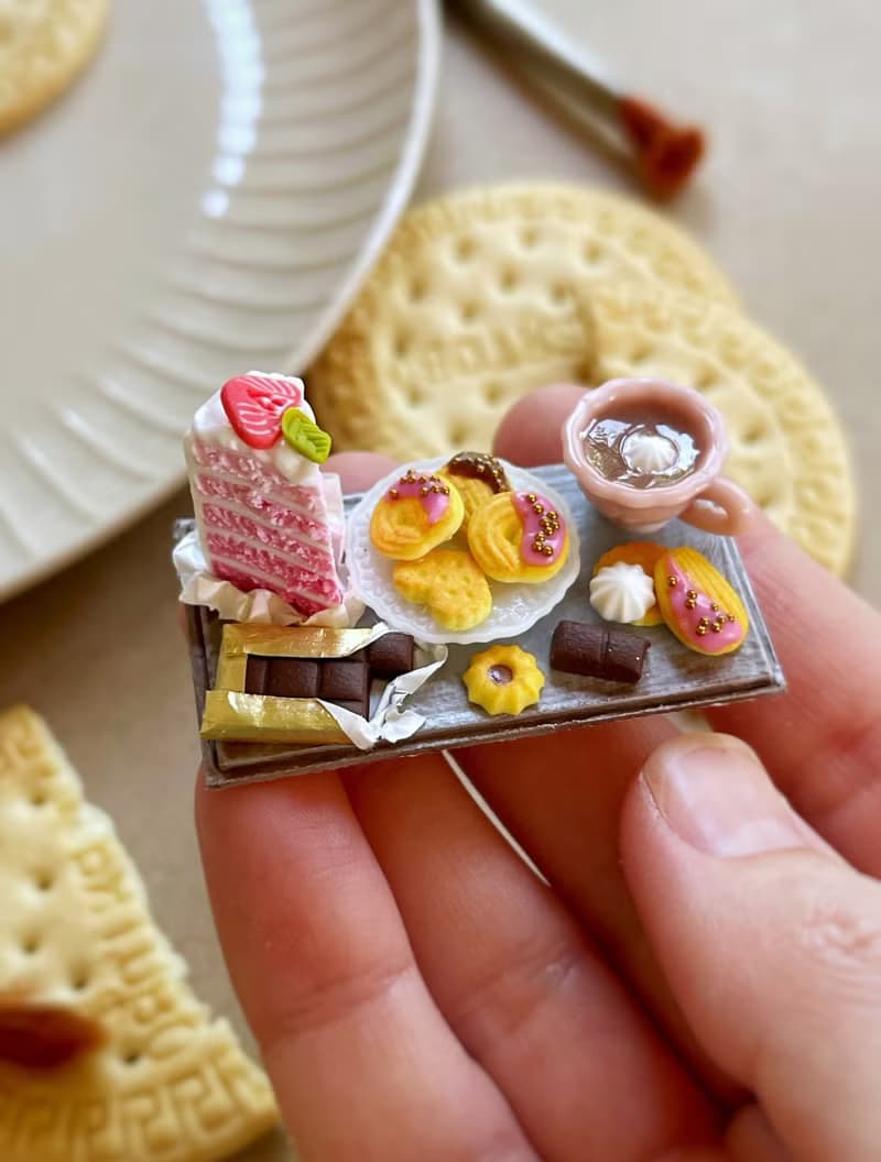 Miniature set of a piece of cake with strawberries, chocolate and a cup of tea