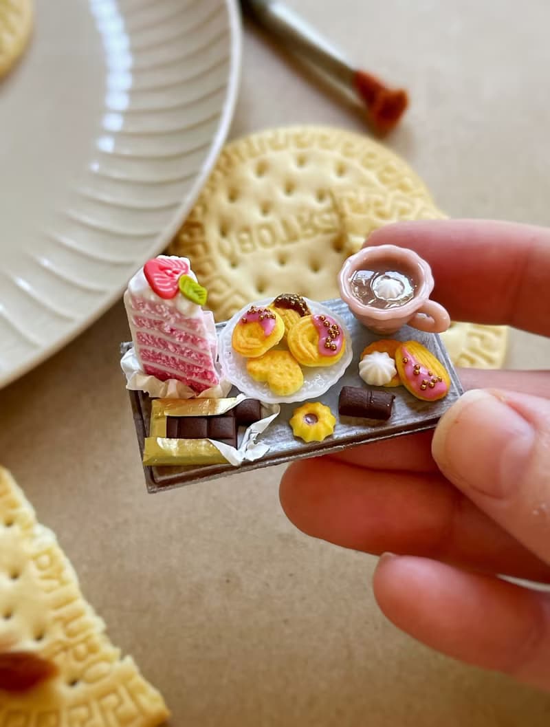 Miniature set of a piece of cake with strawberries, chocolate and a cup of tea