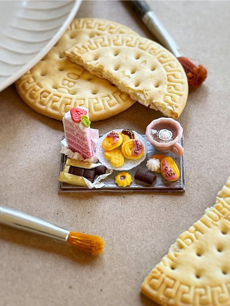 Miniature set of a piece of cake with strawberries, chocolate and a cup of tea