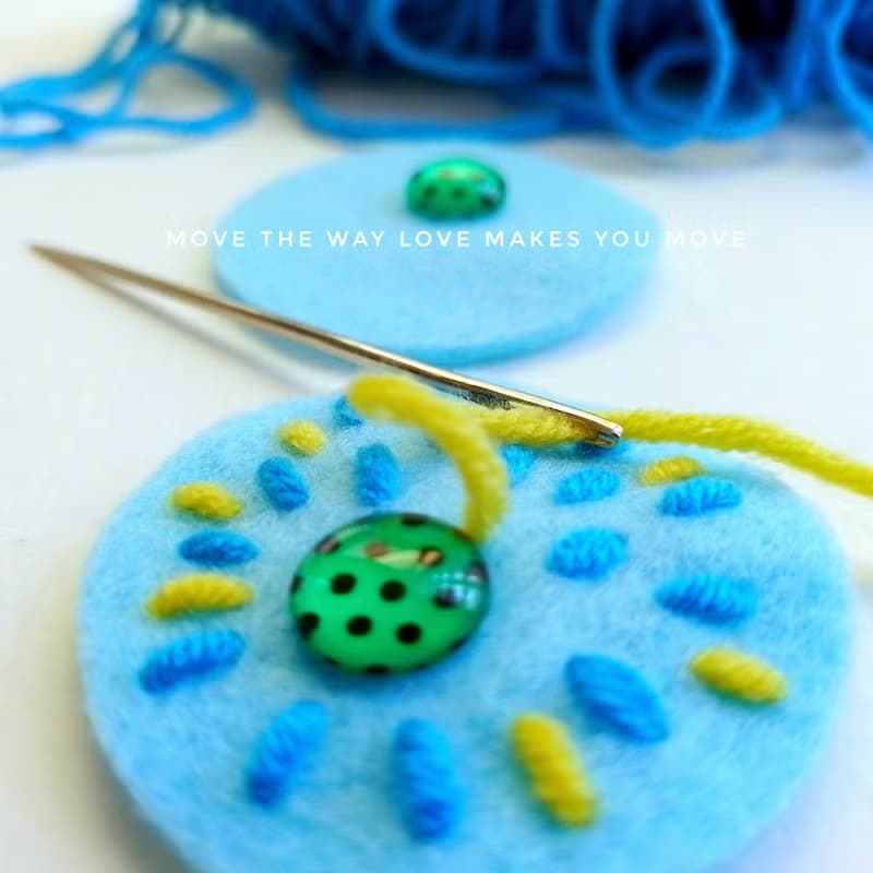Colorful free-form dangle earring design with hand-stitching on felt with beads