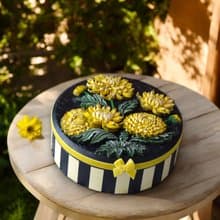 Round jewelry storage box with voluminous yellow chrysanthemum flowers