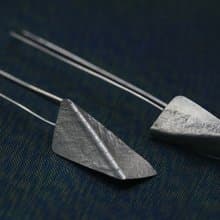 Handmade earrings with bended textured silver pieces on a long stem (E0184)