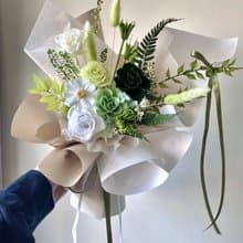 綠色自然系飄逸感永生玫瑰花束。表演獻花。情人節生日告白