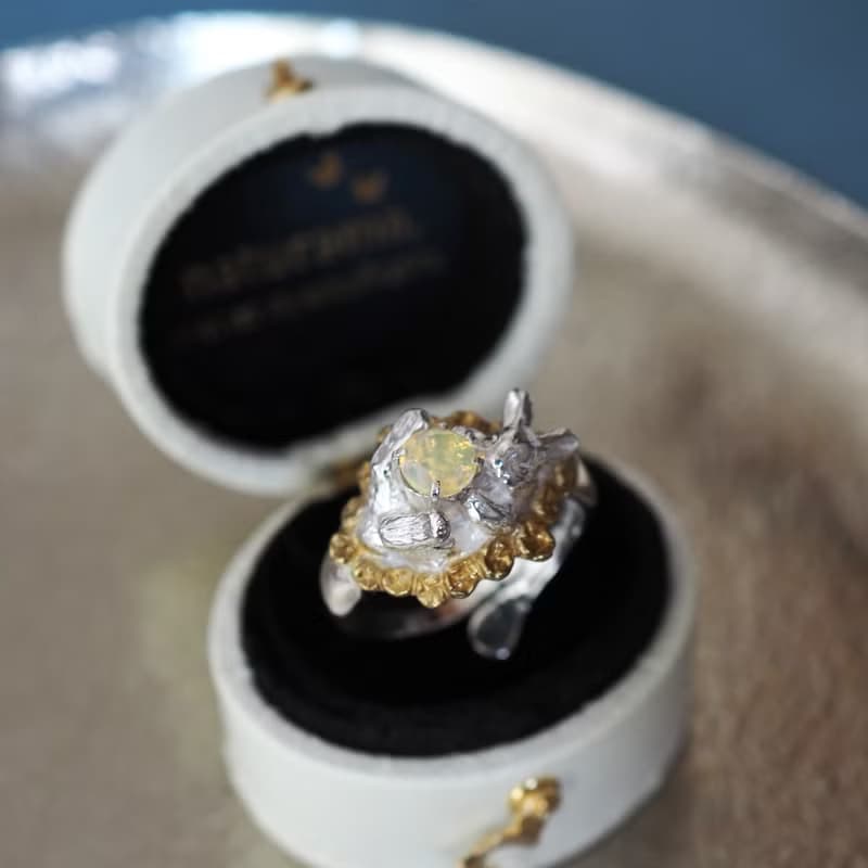 宝石を抱いたお花畑の白うさぎリング オパール