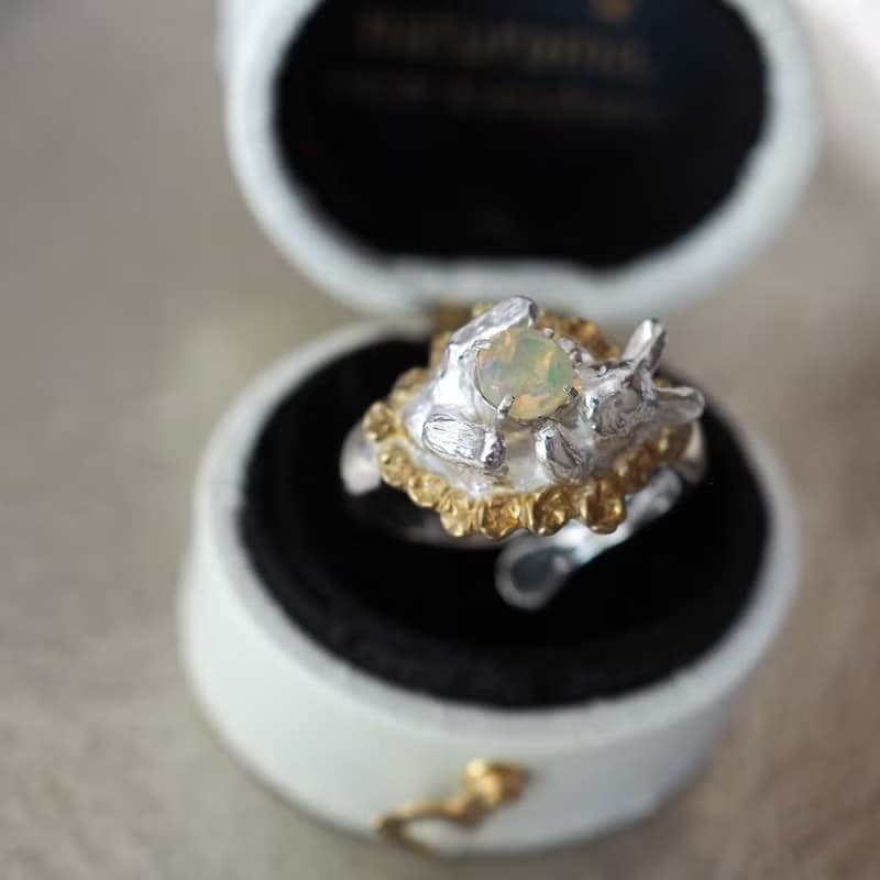 宝石を抱いたお花畑の白うさぎリング オパール