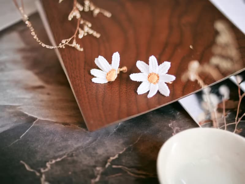 手刺繡耳夾。白晶菊