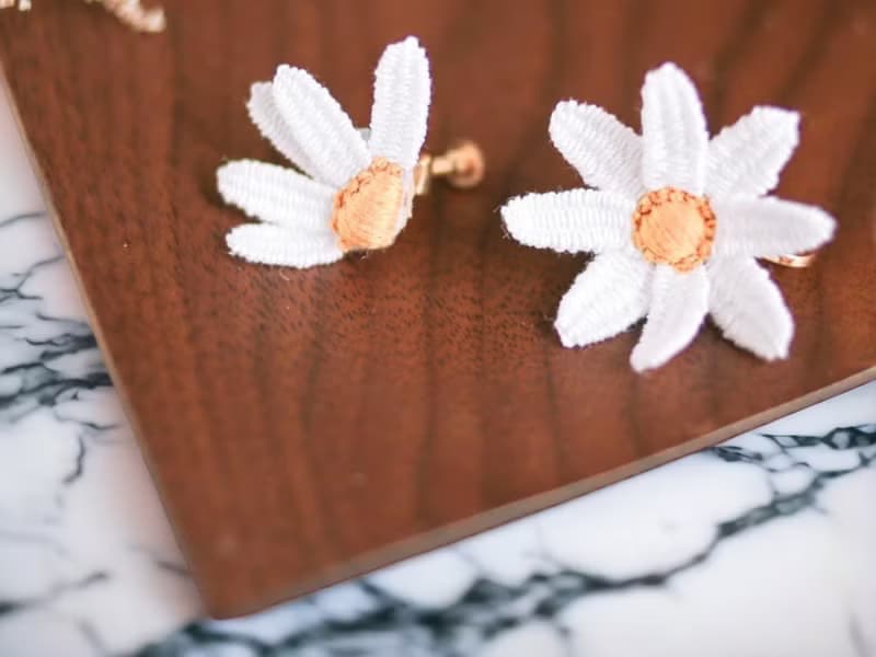 手刺繡耳夾。白晶菊